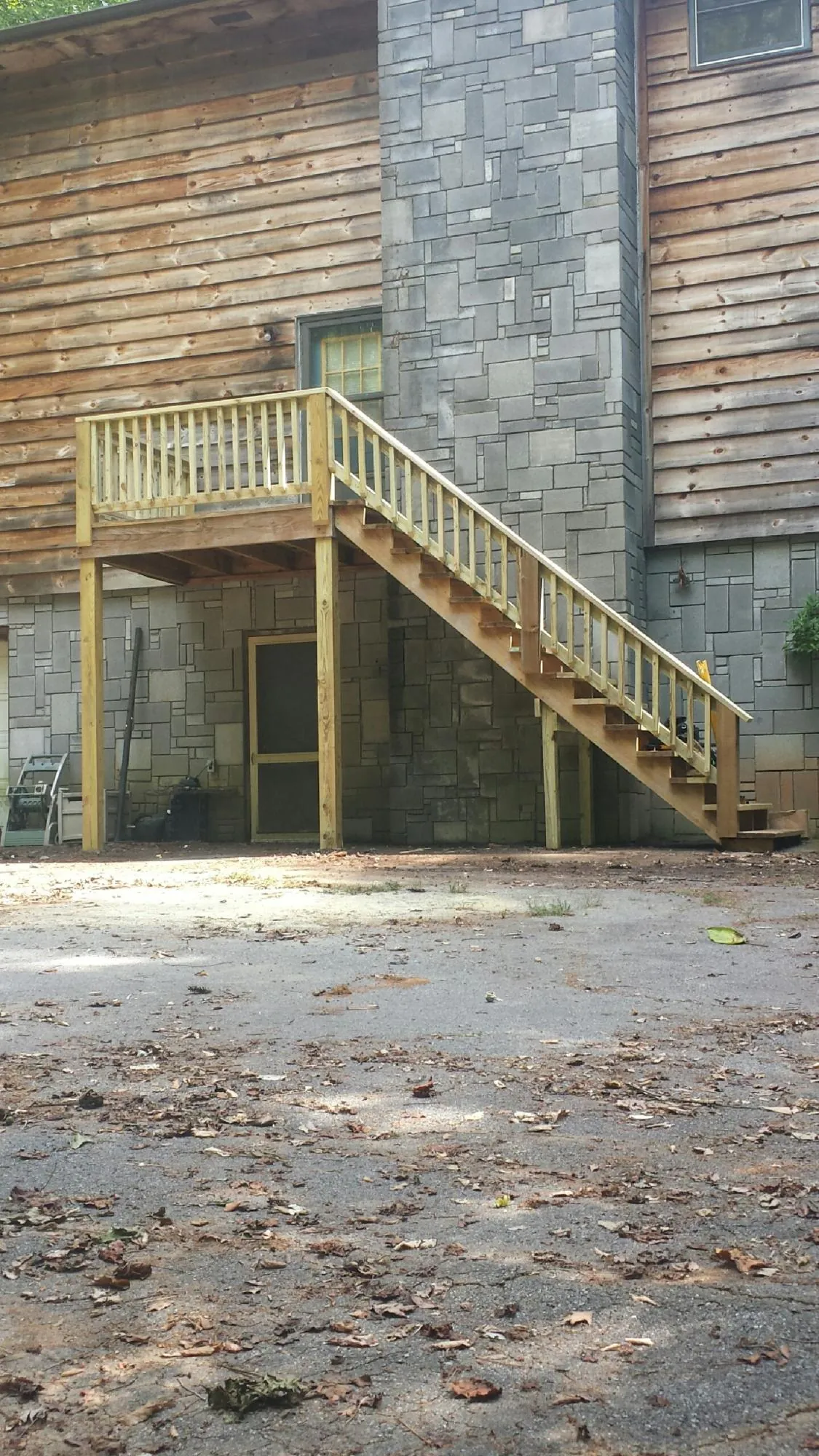 New pressure treated deck and stair landing on a log home in Jacksonville